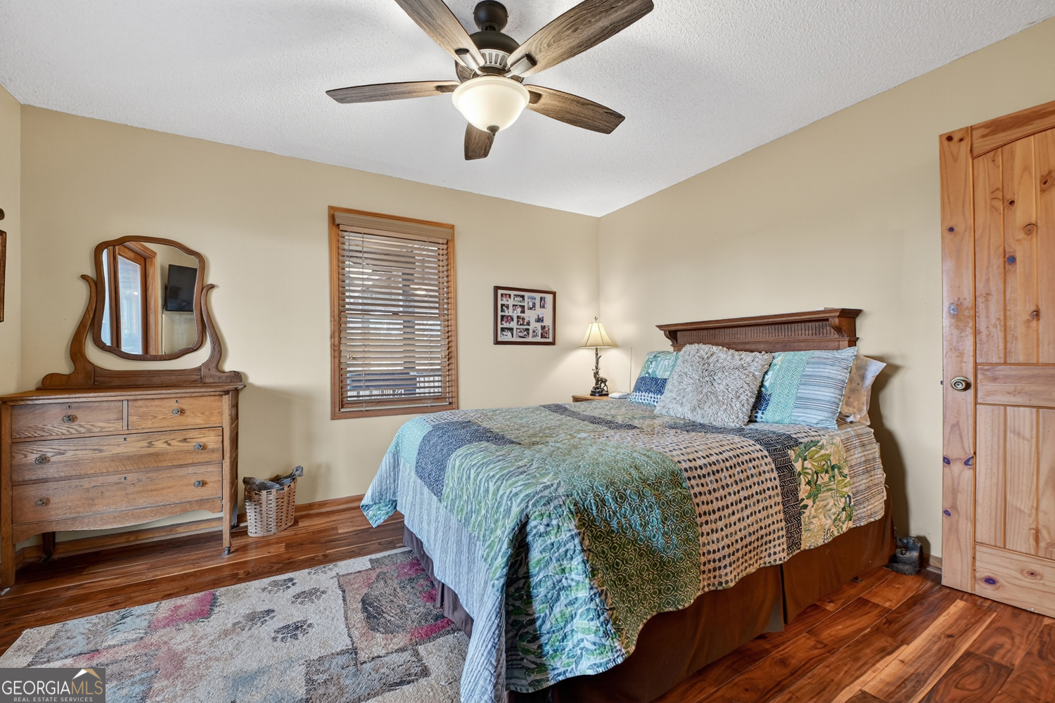 1189 Walnut Ridge, Unit 4044 Ellijay, GA 30536 - Photo 17 of 52 a bedroom with a bed and dresser with wooden floor