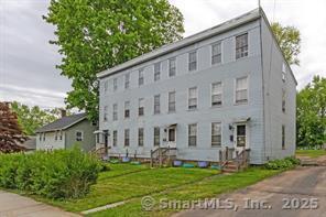 a view of a white house with yard
