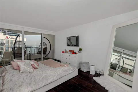 a bedroom with a bed and a flat tv screen on the dresser