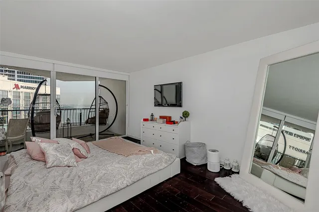 a bedroom with a bed and a flat tv screen on the dresser