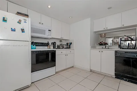 a kitchen with white cabinets and white appliances