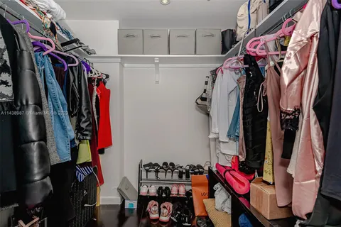 a view of walk in closet with clothes and shoes
