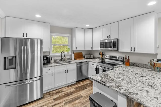 a kitchen with a sink a microwave a refrigerator and cabinets