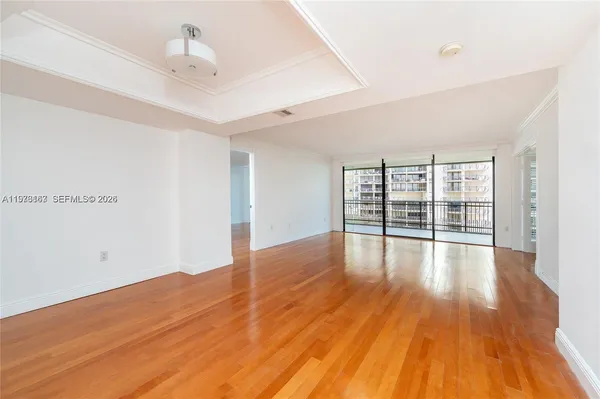 a view of empty room with wooden floor and fan