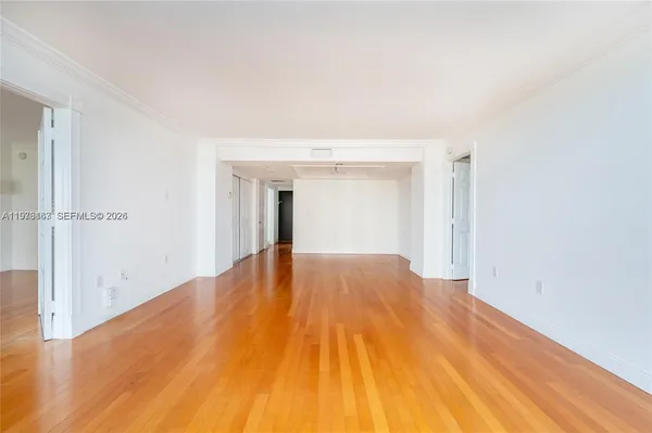 a view of empty room with wooden floor