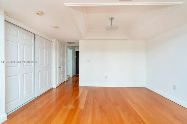 a view of empty room with wooden floor