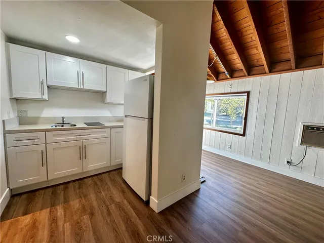 a kitchen with white cabinets white appliances and sink