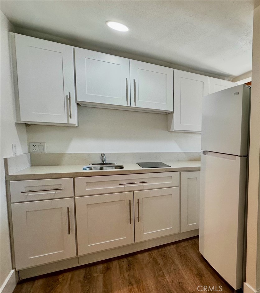 31601 Vía Conejo, Unit 145C Coto de Caza, CA 92679 - Photo 4 of 5 a kitchen with white cabinets white appliances and sink