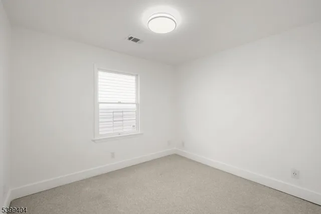 an empty room with a window and wooden floor