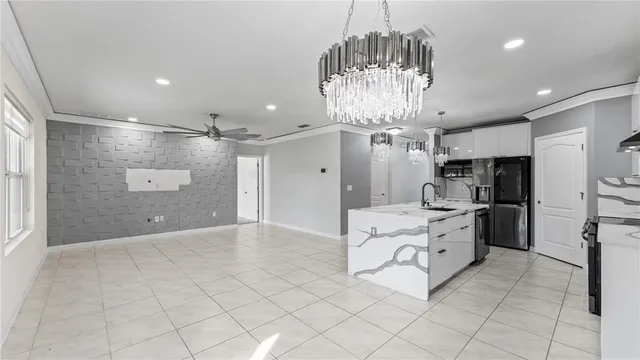 a large kitchen with stainless steel appliances kitchen island granite countertop a refrigerator and a stove top oven