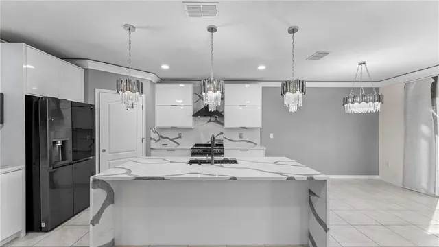 a kitchen with kitchen island a refrigerator and a refrigerator