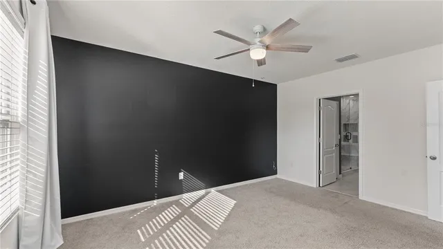 a bedroom with a bed and a ceiling fan