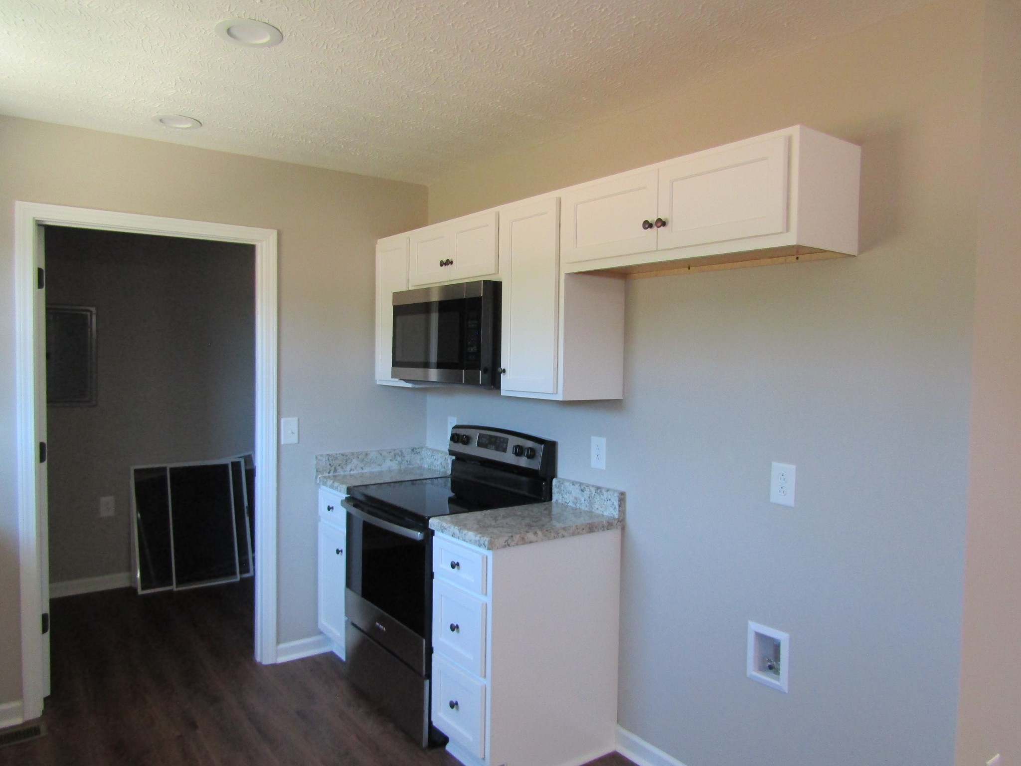 480 Crescent Factory Road Lawrenceburg, TN 38464 - Photo 8 of 14 a kitchen with stainless steel appliances white cabinets and wooden floor