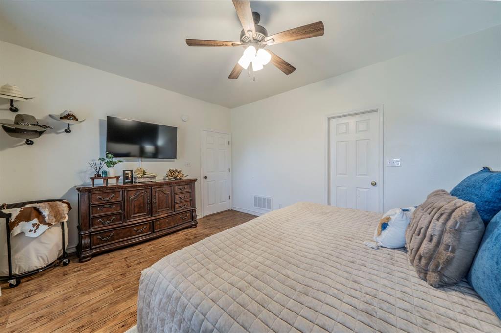 1992 Bledsoe Road Gunter, TX 75058 - Photo 17 of 40 a bedroom with a bed and a flat tv screen on dresser