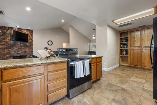 a kitchen with stainless steel appliances granite countertop a stove a sink and a refrigerator