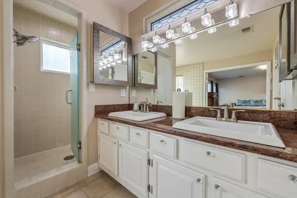 a bathroom with a granite countertop sink mirror and shower