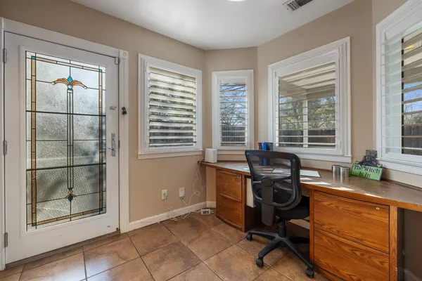 a view of a workspace with furniture and a window