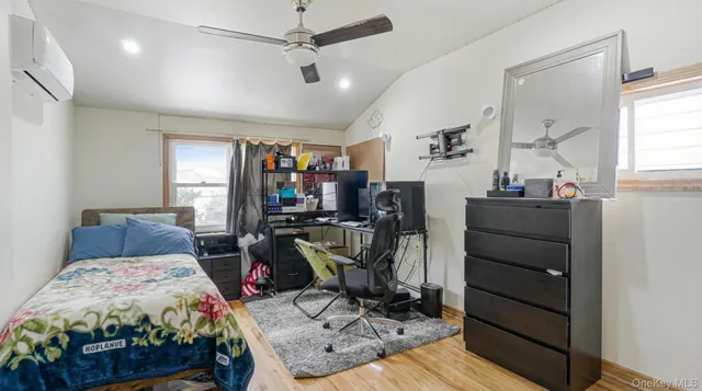 a bedroom with furniture a flat screen tv and a window