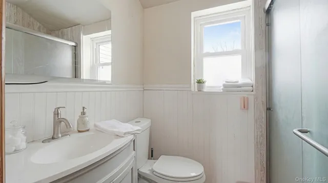 a bathroom with a sink a toilet and a window