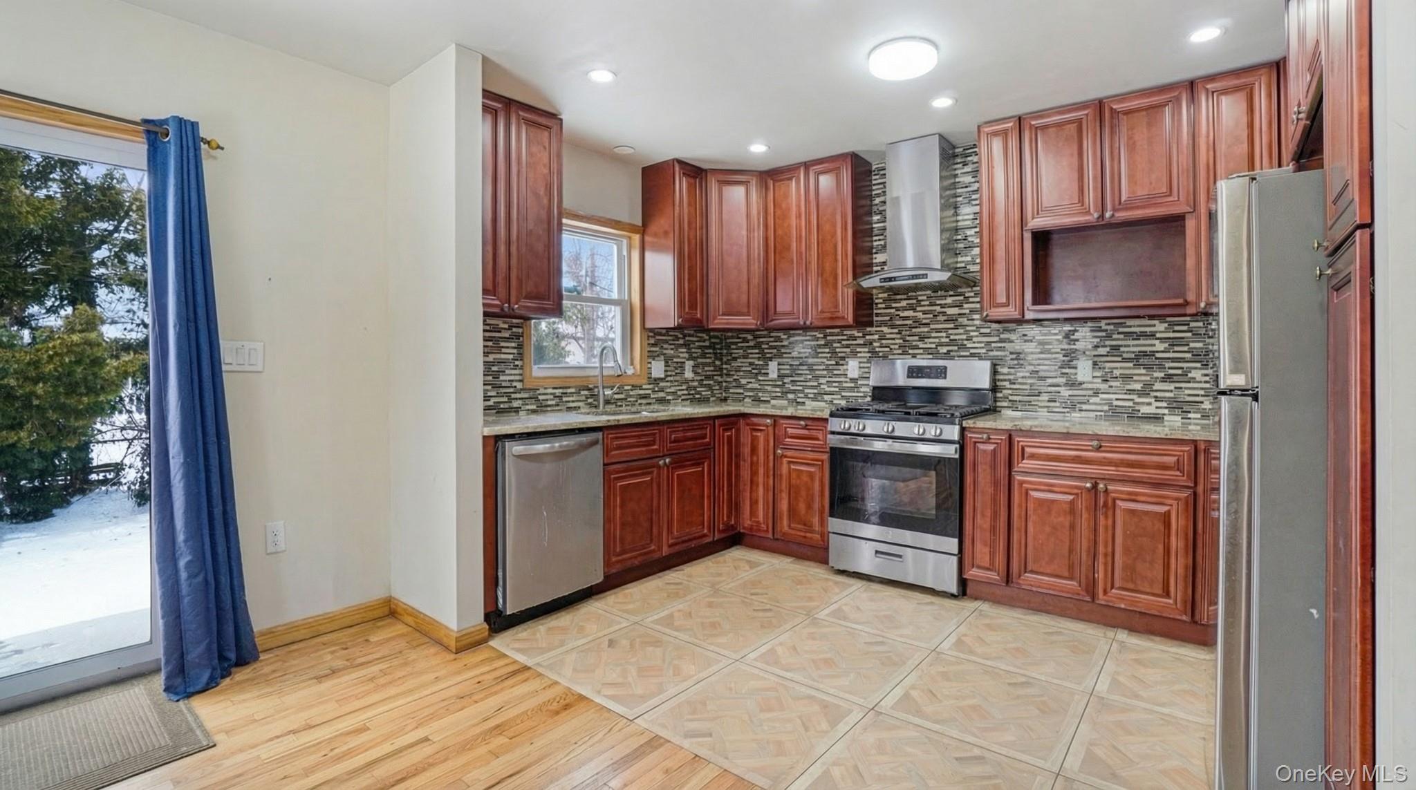 34 Diamond Street Elmont, NY 11003 - Photo 8 of 20 a kitchen with stainless steel appliances granite countertop a stove a sink and a refrigerator