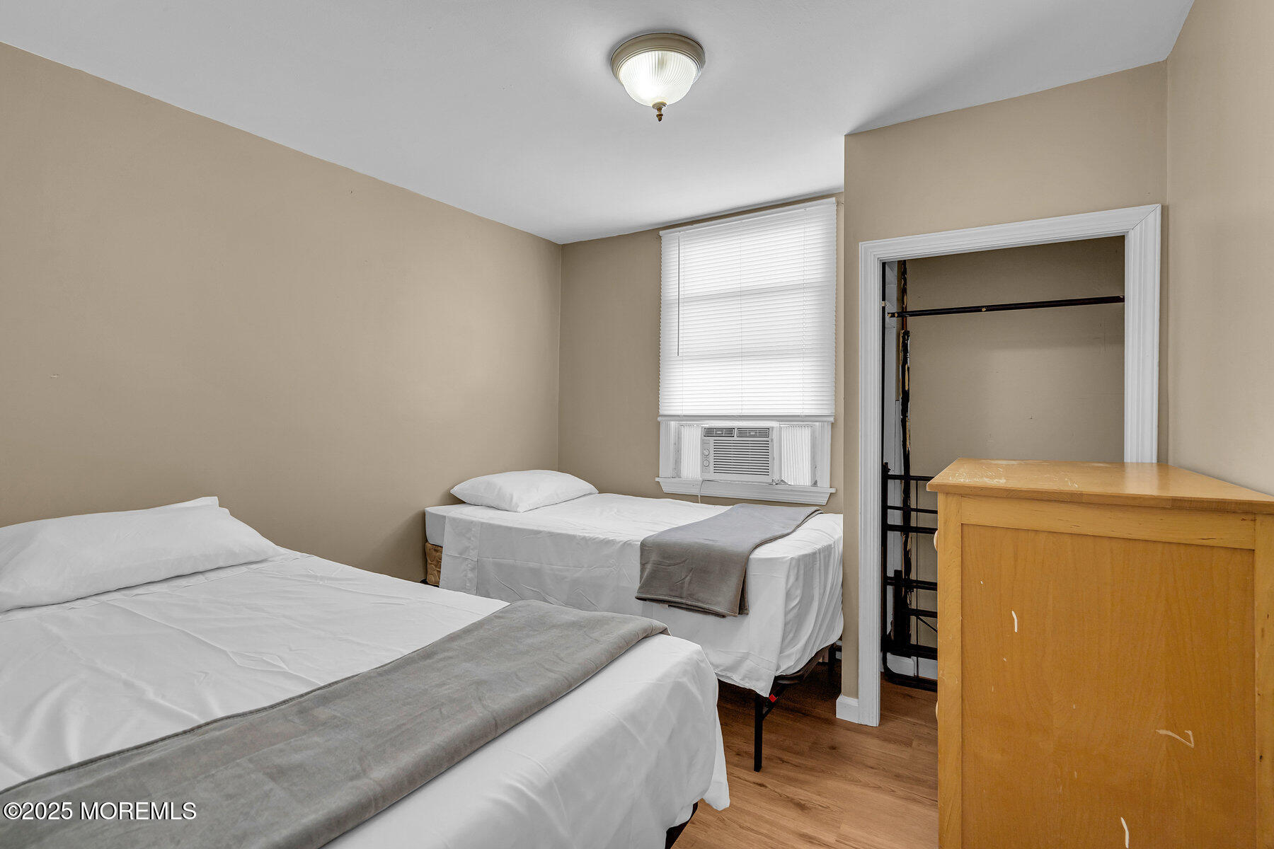 a bedroom with two beds and wooden floor