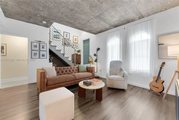 a living room with furniture and a wooden floor