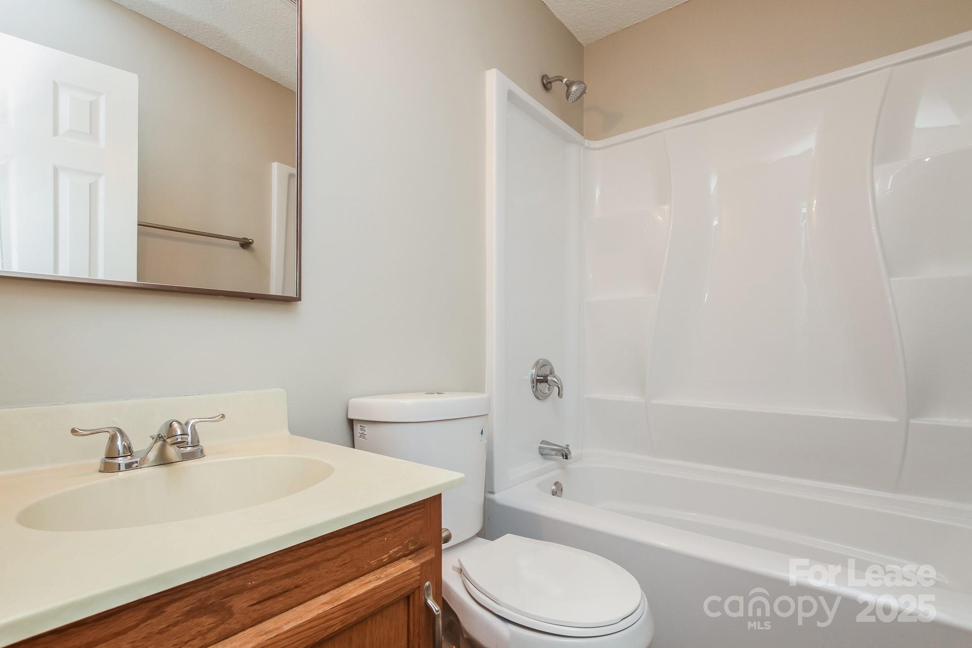 709 Firecrest Street Southeast Concord, NC 28025 - Photo 14 of 16 a bathroom with a sink a toilet and a bathtub
