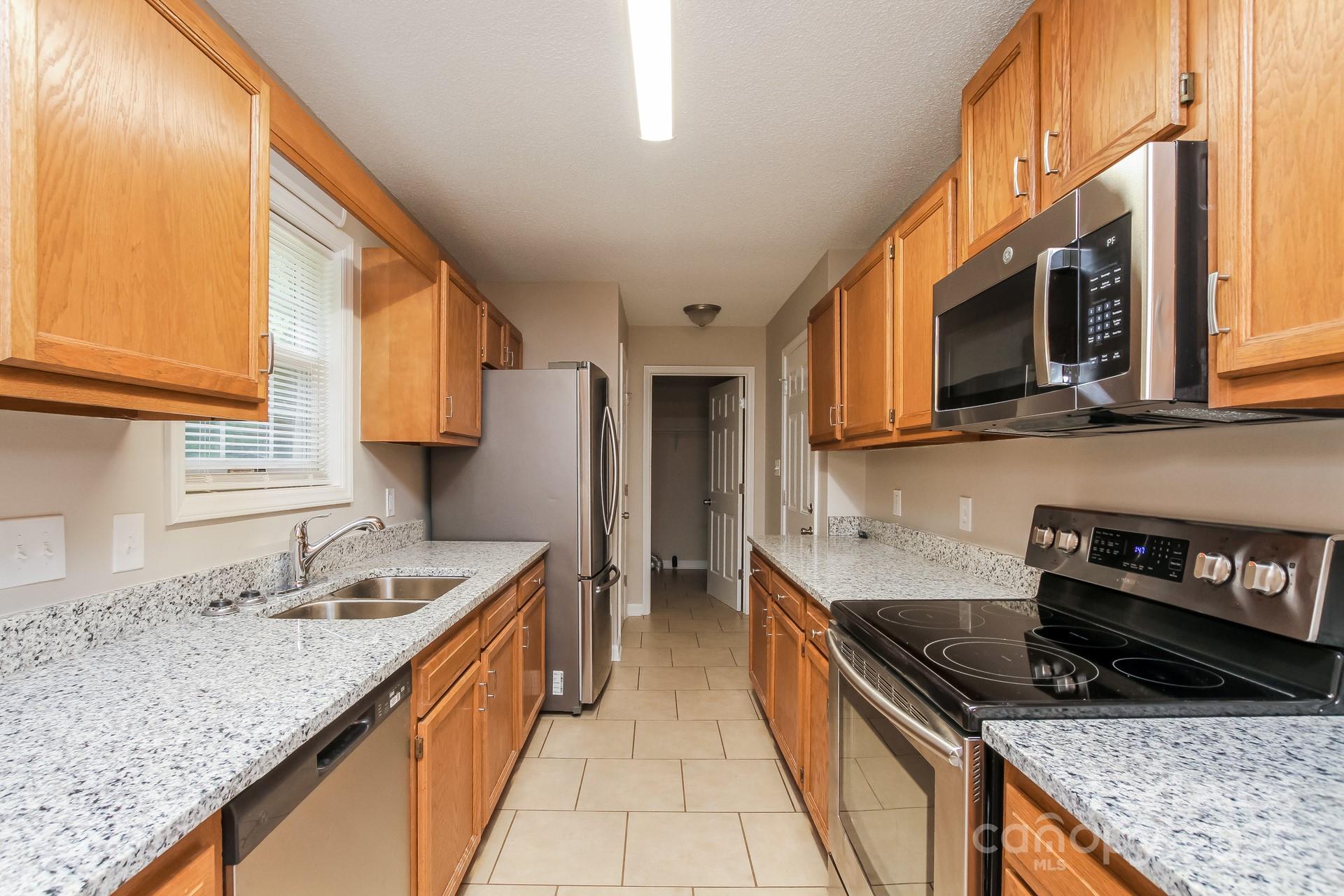 709 Firecrest Street Southeast Concord, NC 28025 - Photo 7 of 16 a kitchen with stainless steel appliances granite countertop a sink stove and refrigerator