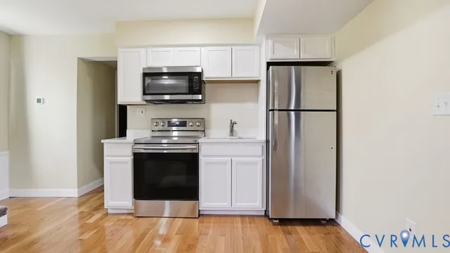 a kitchen with a refrigerator and a stove top oven