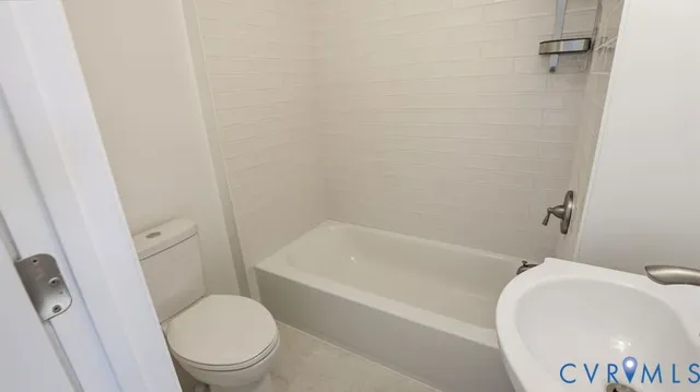 a white bath tub sitting next to a white sink