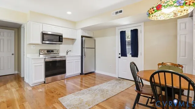 a kitchen with white cabinets and stainless steel appliances
