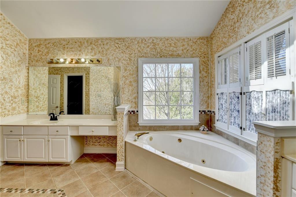 2382 Merrymount Drive Suwanee, GA 30024 - Photo 32 of 93 a large spacious bathroom with a large tub a sink and a large window