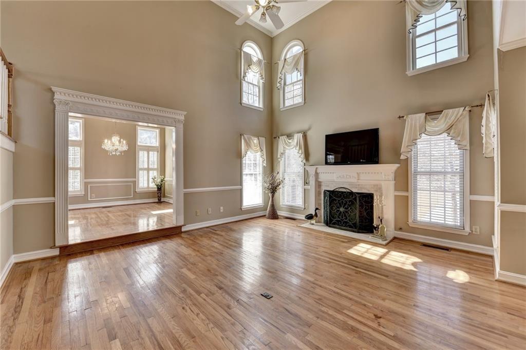 2382 Merrymount Drive Suwanee, GA 30024 - Photo 5 of 93 a view of a livingroom with wooden floor a fireplace and windows