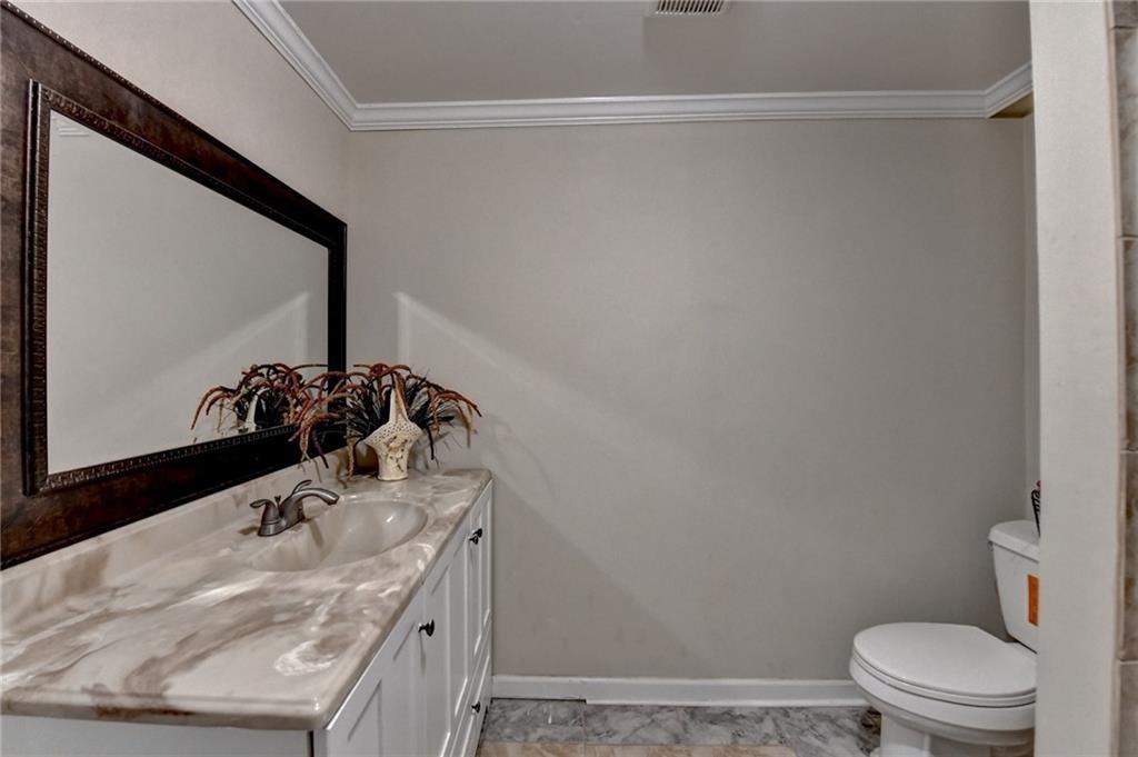 2382 Merrymount Drive Suwanee, GA 30024 - Photo 54 of 93 a bathroom with a granite countertop sink a toilet and a mirror