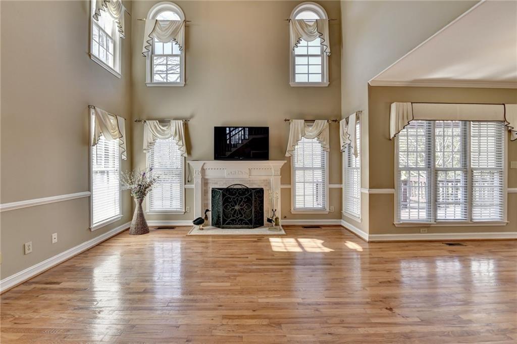 2382 Merrymount Drive Suwanee, GA 30024 - Photo 7 of 93 a view of a livingroom with fireplace wooden floor and windows