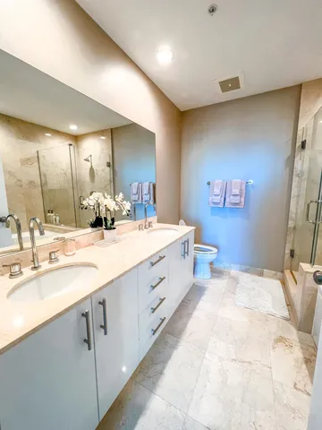 a spacious bathroom with a double vanity sink and a mirror