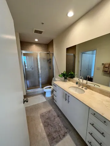 a bathroom with a double vanity sink toilet mirror and bathtub