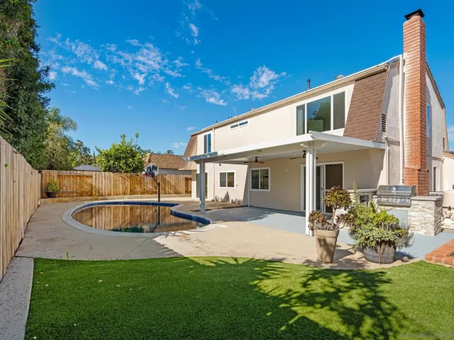 a view of a house with backyard and sitting area