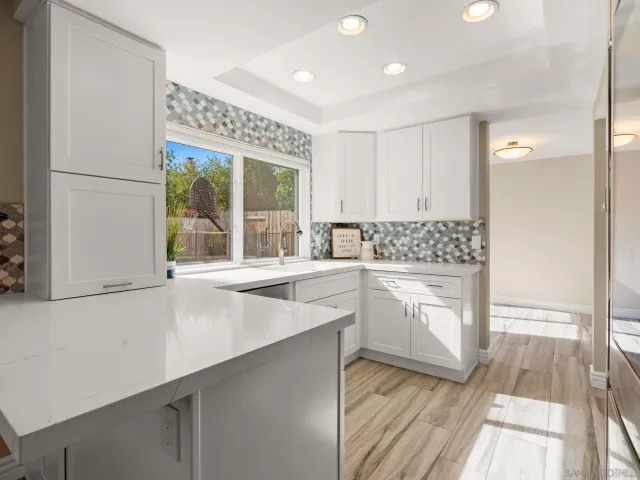 a kitchen with white cabinets and white appliances