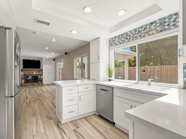 a large kitchen with stainless steel appliances granite countertop a lot of counter space and wooden floors