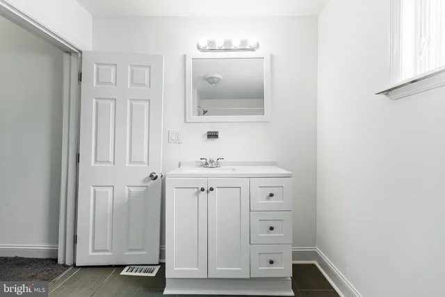 a bathroom with a sink a mirror and a vanity