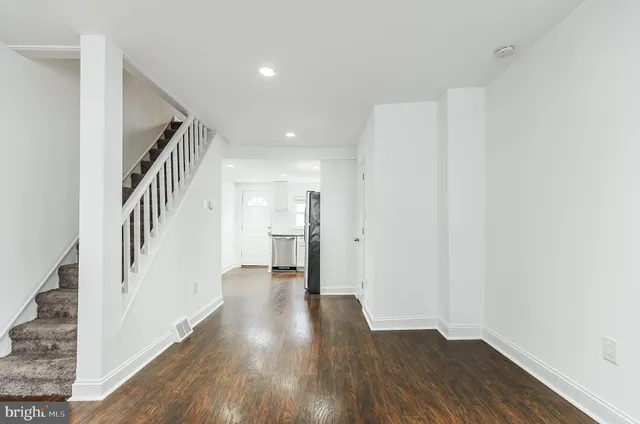 a view of a hallway with wooden floor and entryway