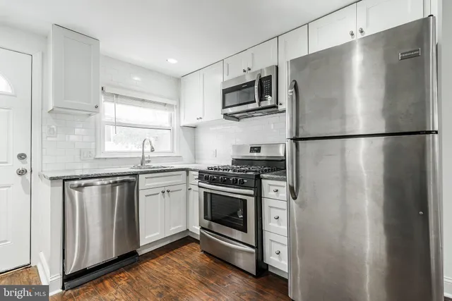 a kitchen with stainless steel appliances a refrigerator sink and microwave