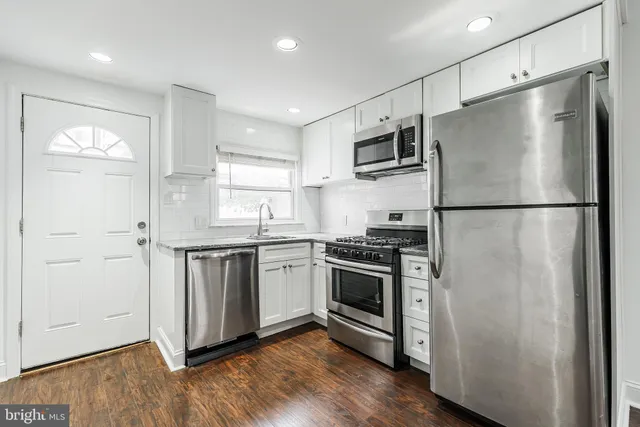 a kitchen with stainless steel appliances a refrigerator sink and microwave