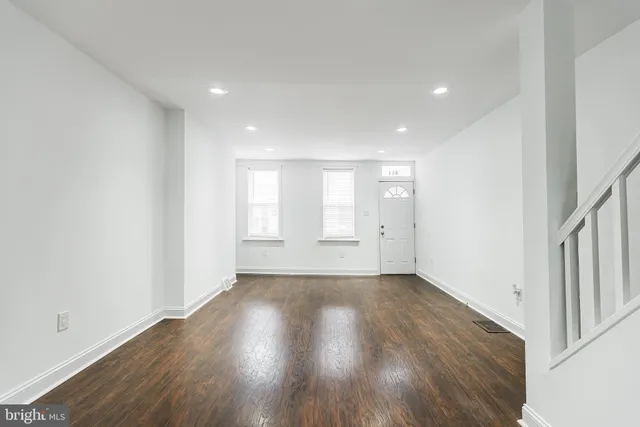 a view of an empty room with wooden floor