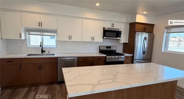 a kitchen with stainless steel appliances a stove sink microwave and refrigerator