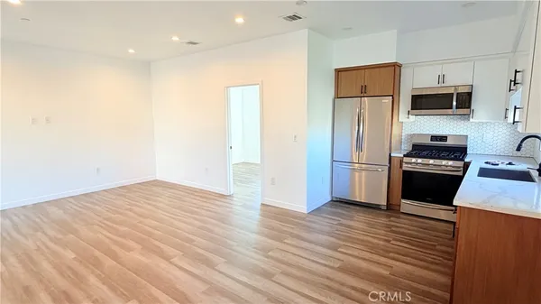a kitchen with stainless steel appliances a refrigerator and a stove top oven