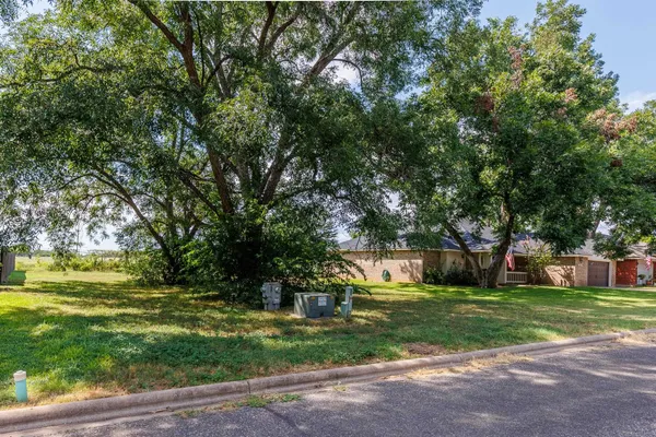 a view of a house with a big yard and large trees