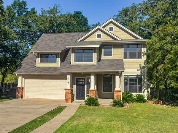 a front view of a house with a yard and trees