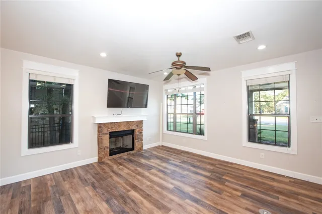 a view of an empty room with a window and fireplace